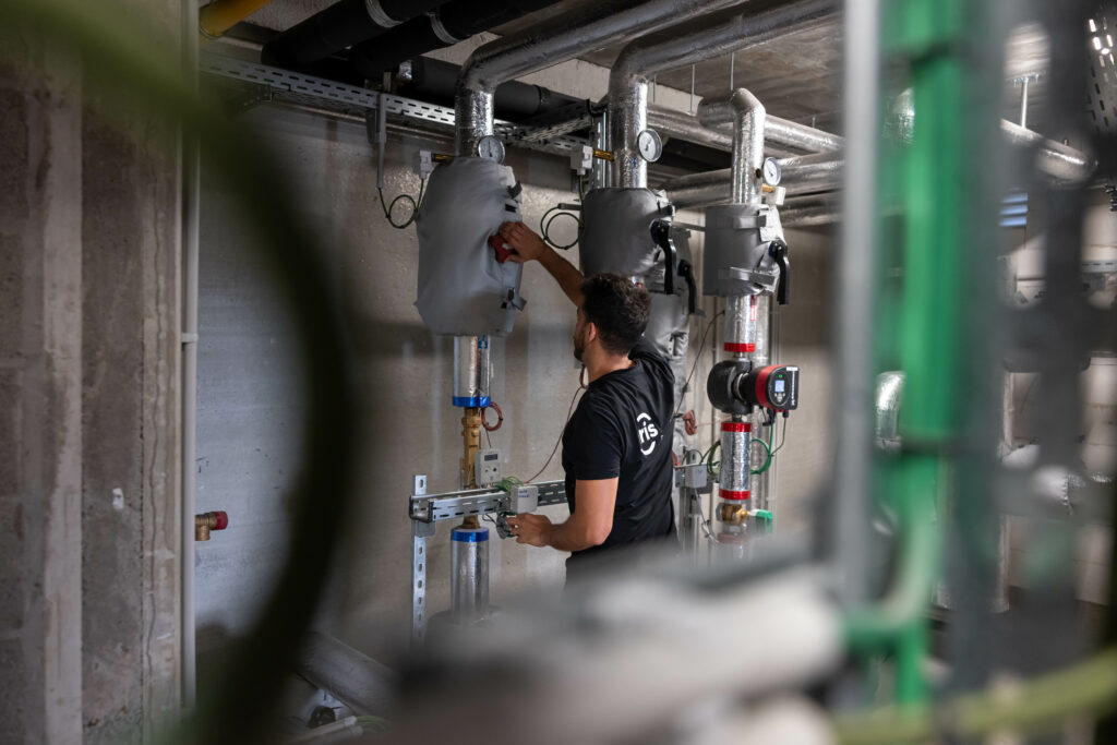 Technicus werkt aan verwarmingssysteem in technische ruimte.
