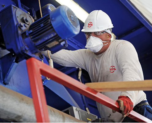 Technicus werkt aan industriële machine, veiligheidsuitrusting aan