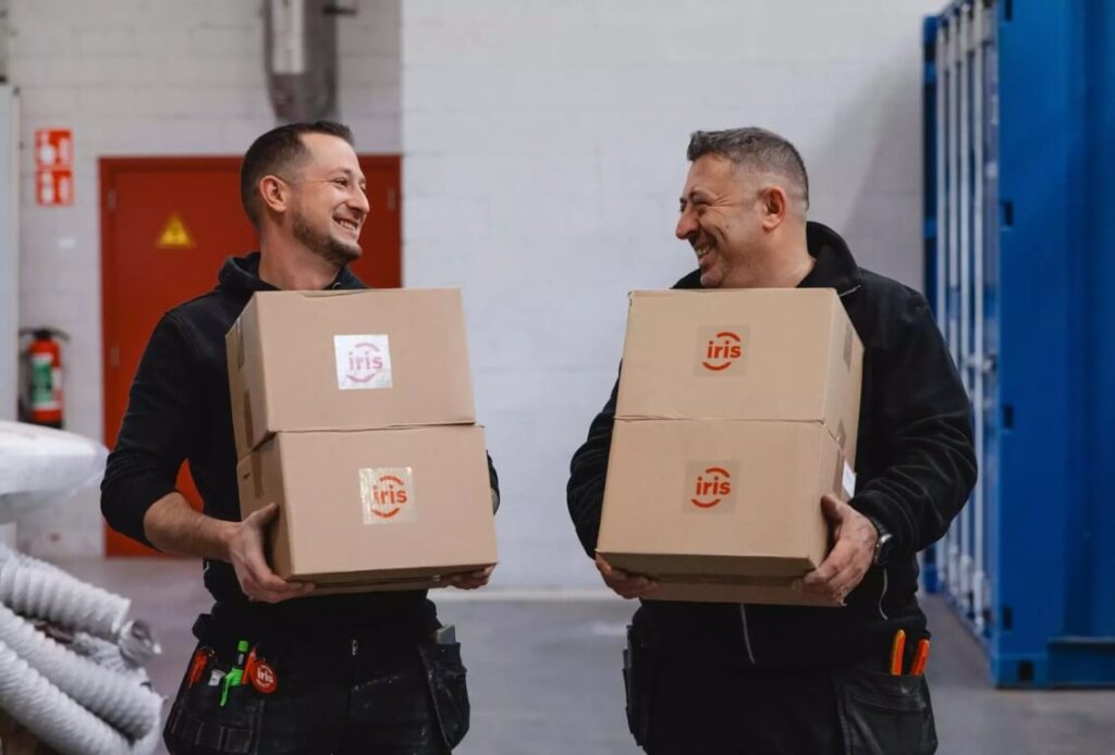 Deux hommes transportent en riant des cartons dans l'entrepôt.